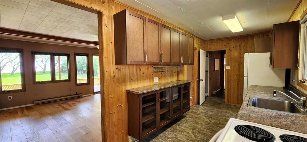 Kitchen and living room at 13 16th Avenue, with a wall of windows looking out to the lawn and lake
