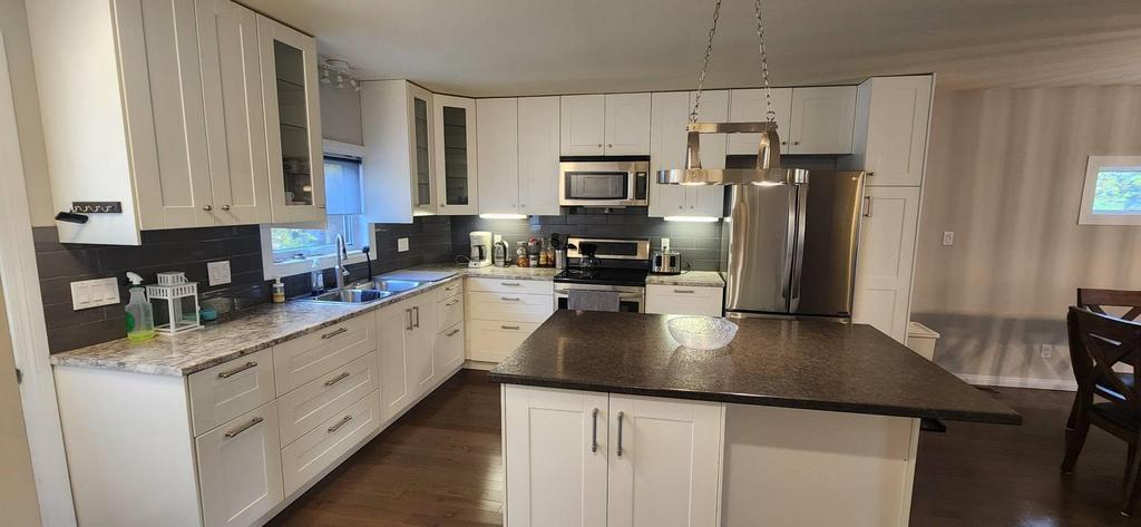 189 6th Street, Gimli &middot; kitchen with white cabinets, stainless appliances and a large island