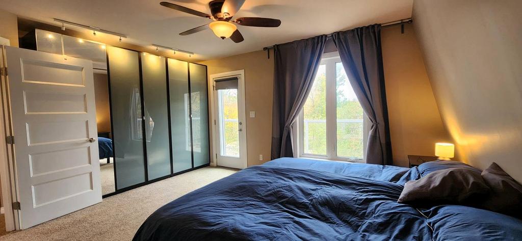 189 6th Street, Gimli &middot; primary bedroom with a mirrored closet and the door to the balcony