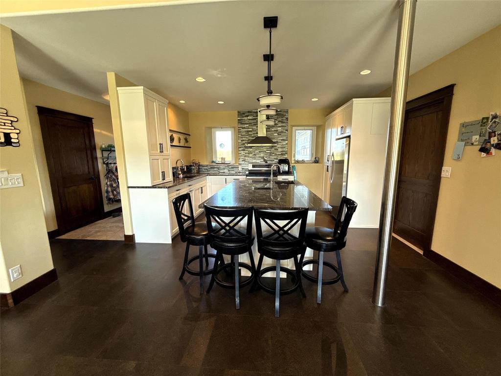 20053 Minerva Road &middot; the dining table with the kitchen beyond, dark wood floors throughout