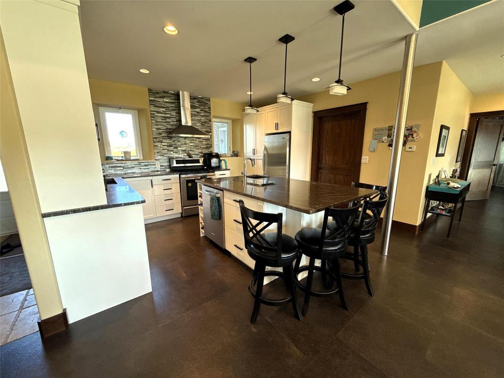 20053 Minerva Road &middot; the kitchen island under pendant lights, with the dining table alongside