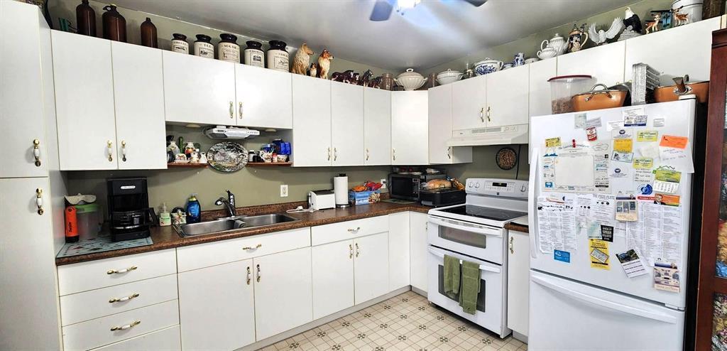 Kitchen at 310 Epsilon Avenue with white cabinetry, electric range, and refrigerator