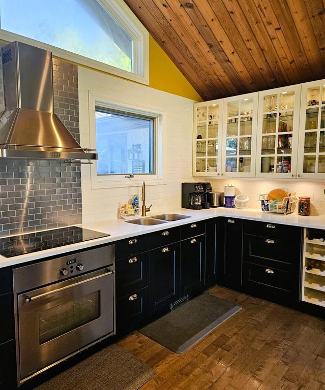 34 Nicklaus Drive, Sandy Hook · kitchen with range hood, dark cabinets and glass-front uppers