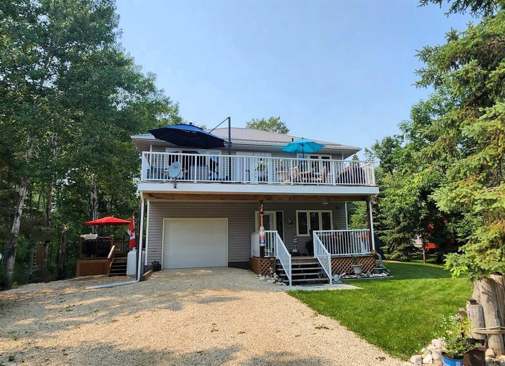 35 Thorvaldson Drive, Arnes · front elevation with the attached garage, driveway, and upper deck
