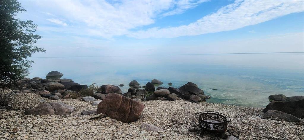 41 Little Deer Road &middot; the rocky shoreline with a firepit and open water beyond