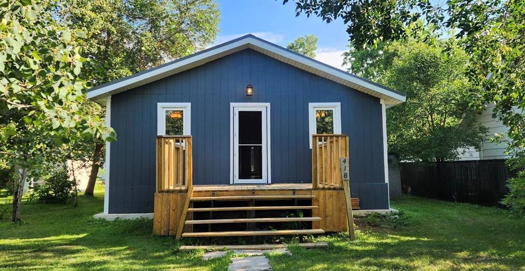 418 Oak Avenue, Winnipeg Beach · front of the blue bungalow with white trim and a new wood front deck
