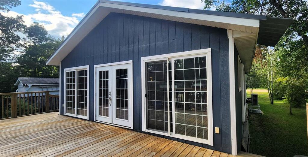 418 Oak Avenue, Winnipeg Beach · side of the house from the deck, with the sunroom's french doors and patio door