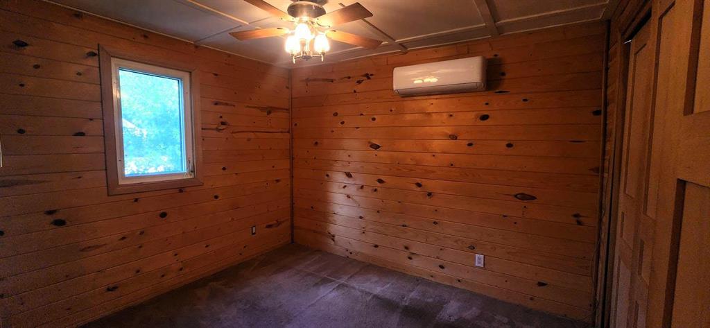418 Oak Avenue, Winnipeg Beach · bedroom with pine walls, carpet, ceiling fan and a ductless mini-split