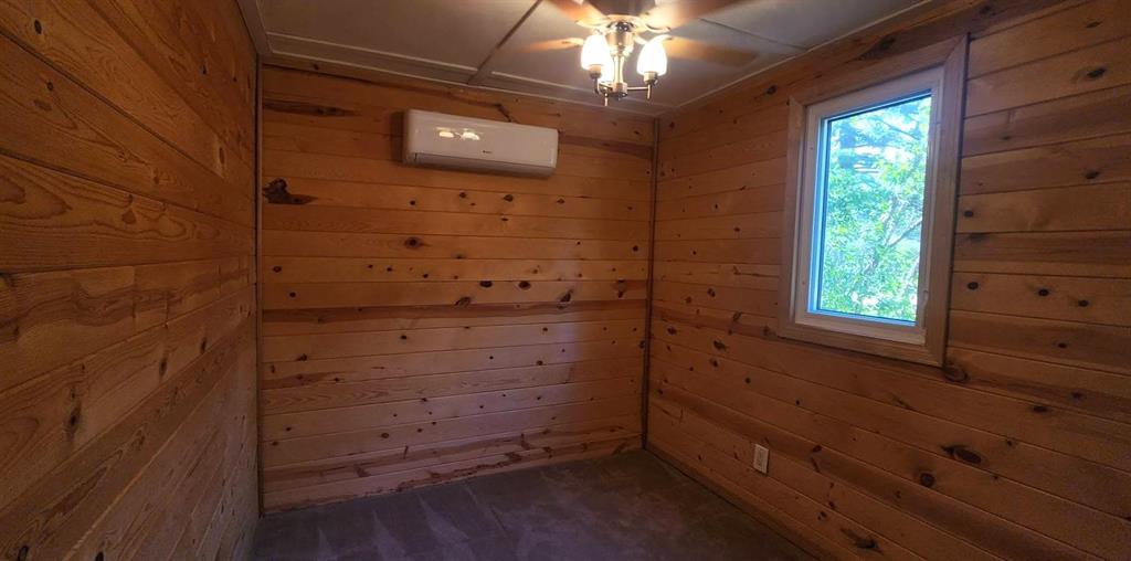 418 Oak Avenue, Winnipeg Beach · bedroom with pine walls, carpet and a ductless mini-split