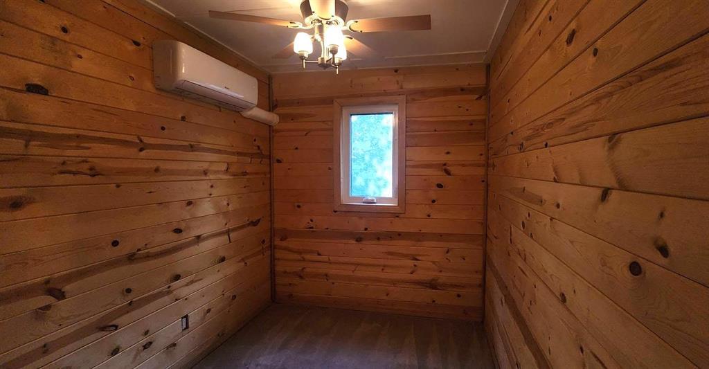 418 Oak Avenue, Winnipeg Beach · bedroom with pine walls, carpet and a ductless mini-split