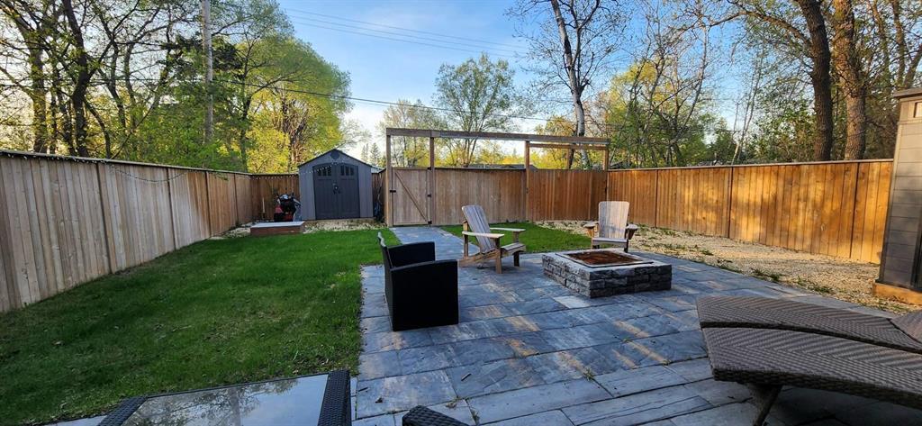 Backyard firepit and patio at 529 Ash Avenue with Adirondack chairs
