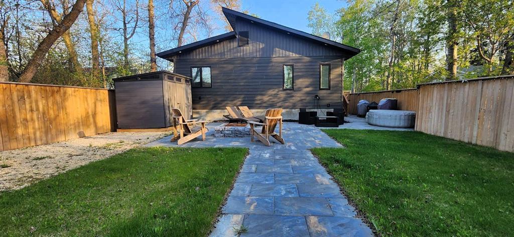 Fully fenced backyard at 529 Ash Avenue with paver patio, firepit area, and storage shed