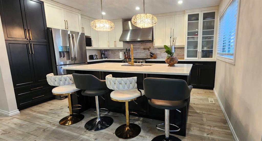 Kitchen at 529 Ash Avenue with quartz island, four bar stools, and pendant lighting
