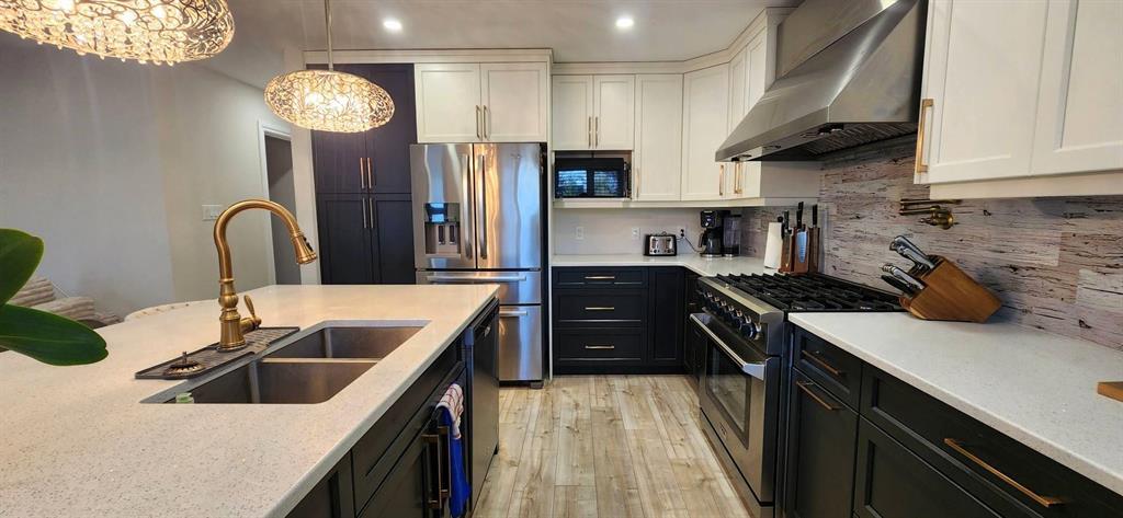 Kitchen at 529 Ash Avenue with 6-burner gas range, stainless fridge, and tile backsplash
