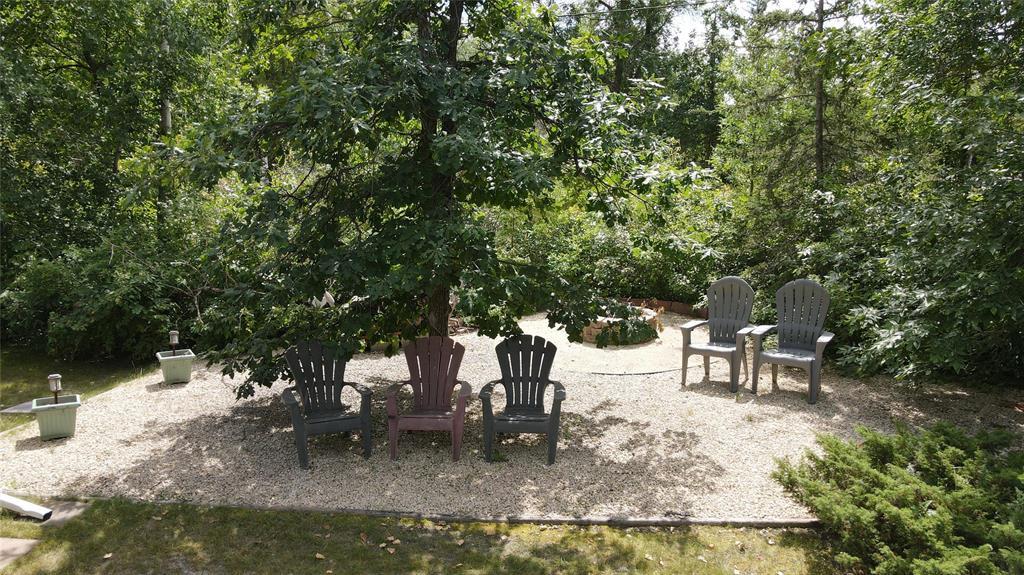 560 Prospect Street, Winnipeg Beach · firepit ringed with Muskoka chairs under the trees