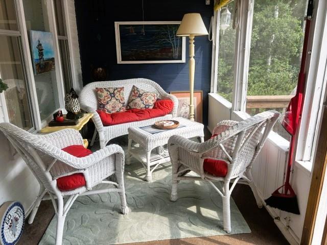 560 Prospect Street, Winnipeg Beach · enclosed porch with white wicker seating and windows on three sides