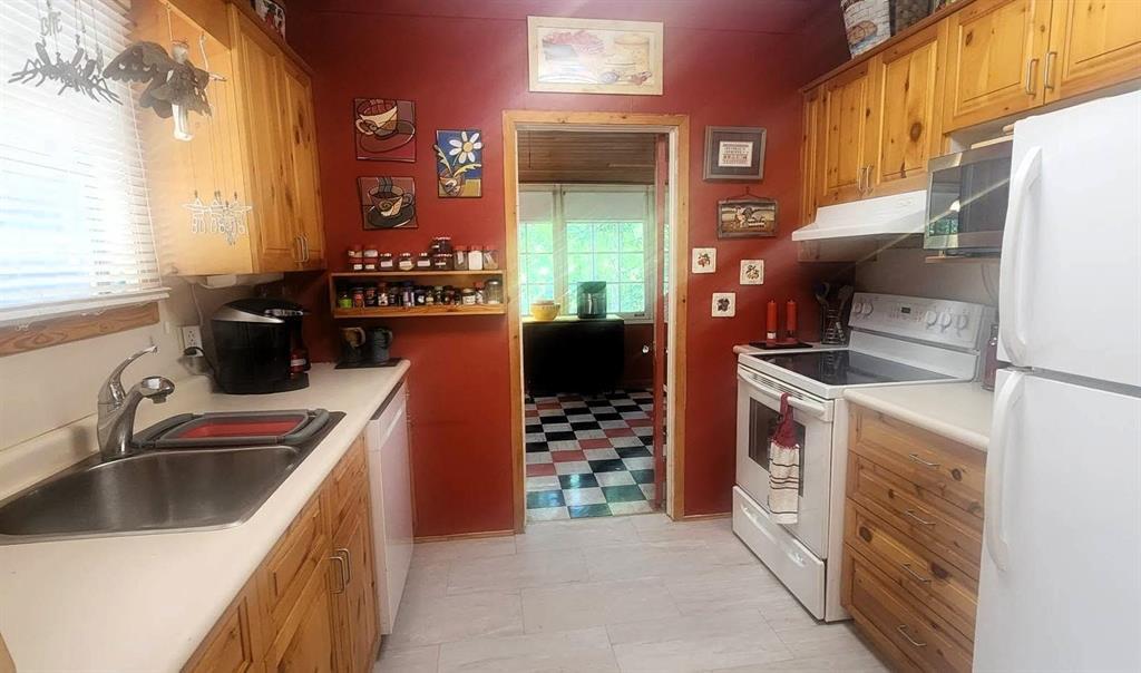 560 Prospect Street, Winnipeg Beach · kitchen with pine cabinetry, red walls and a window over the sink