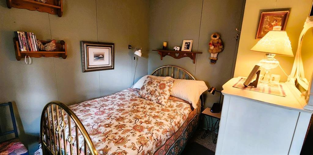 560 Prospect Street, Winnipeg Beach · bedroom with a brass bed and bedside lamp