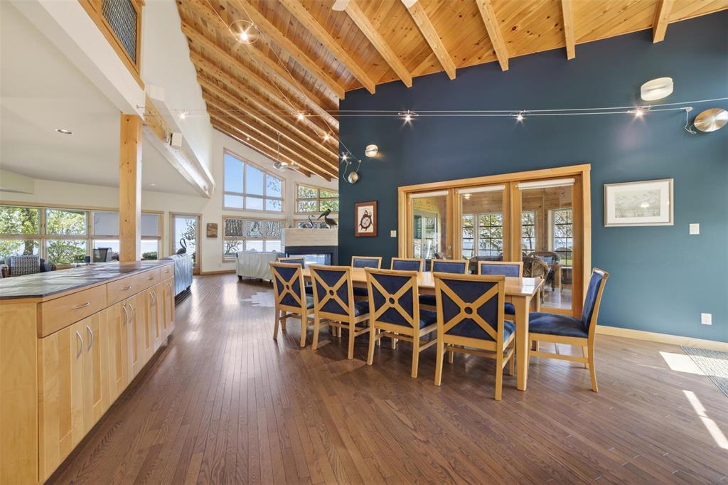 The vaulted great room and dining area at 64 Mercury Drive, with wood-beam ceilings and lake views