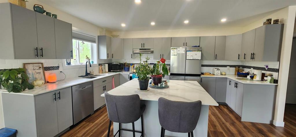 Open-concept island kitchen at 7 Surtsey Road with quartz-look counters and stainless steel appliances