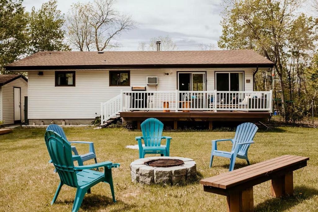899 PTH 9 Highway, Winnipeg Beach &middot; the back of the house and deck, looking across the lawn to the firepit