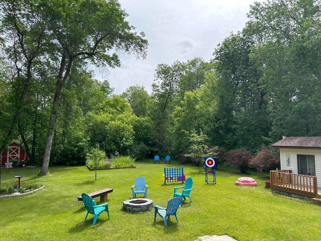 899 PTH 9 Highway, Winnipeg Beach &middot; the treed back yard with a firepit and open lawn